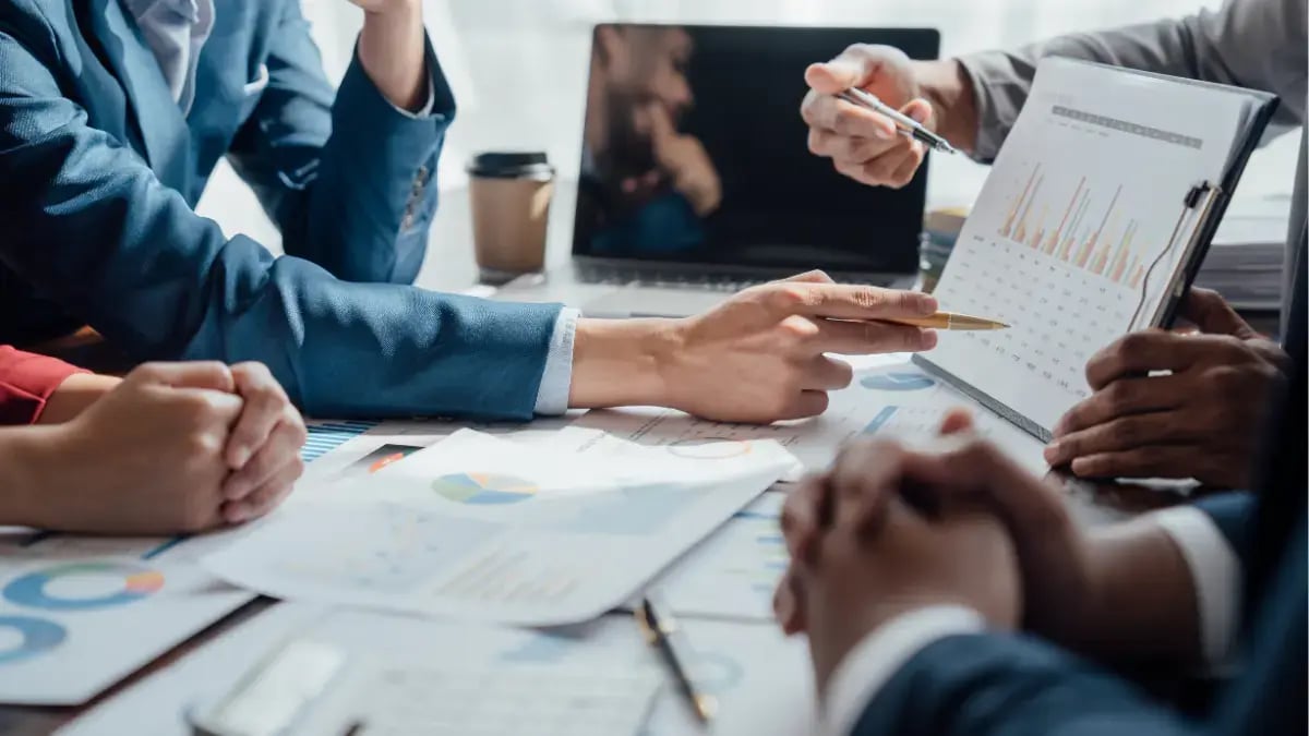 Business team analyzing financial charts and performance reports during a strategy meeting.